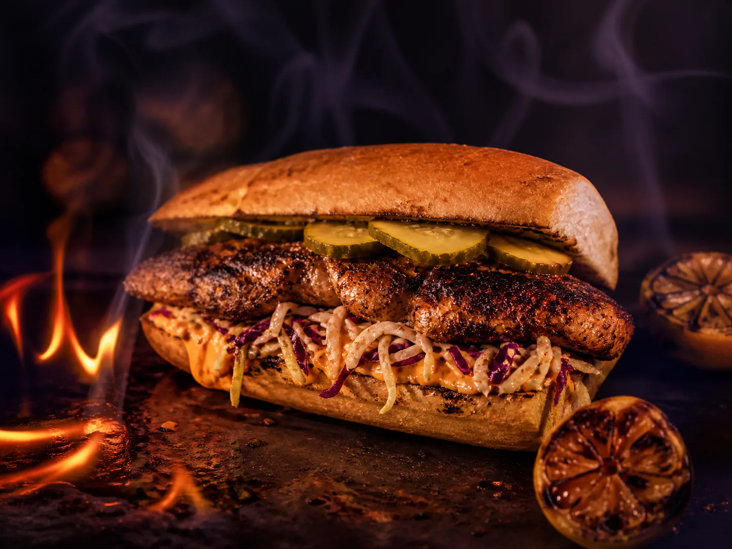 Blackened catfish po'boy with charred citrus and a small flame